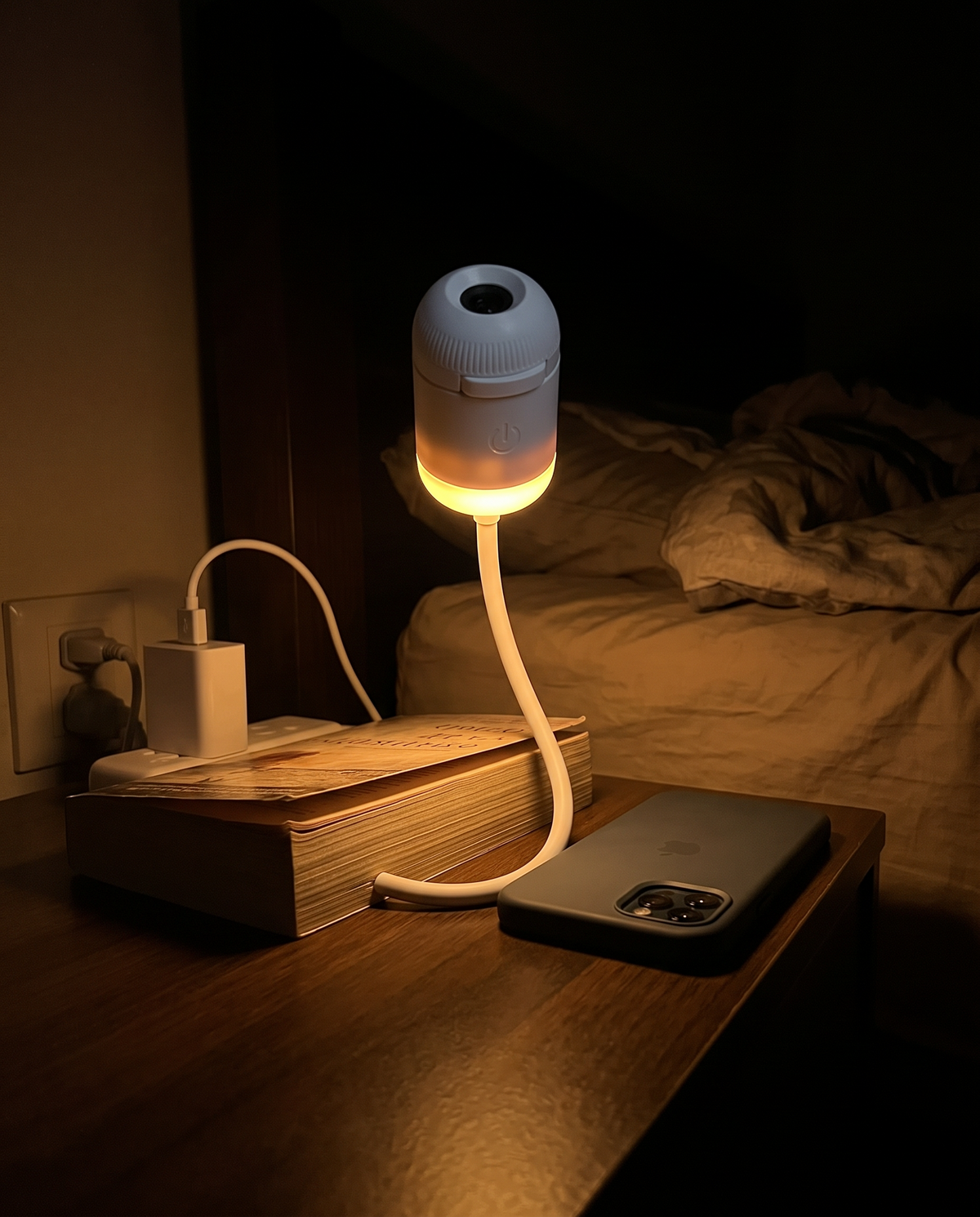 The projector used as a soft warm night light on a bedside table