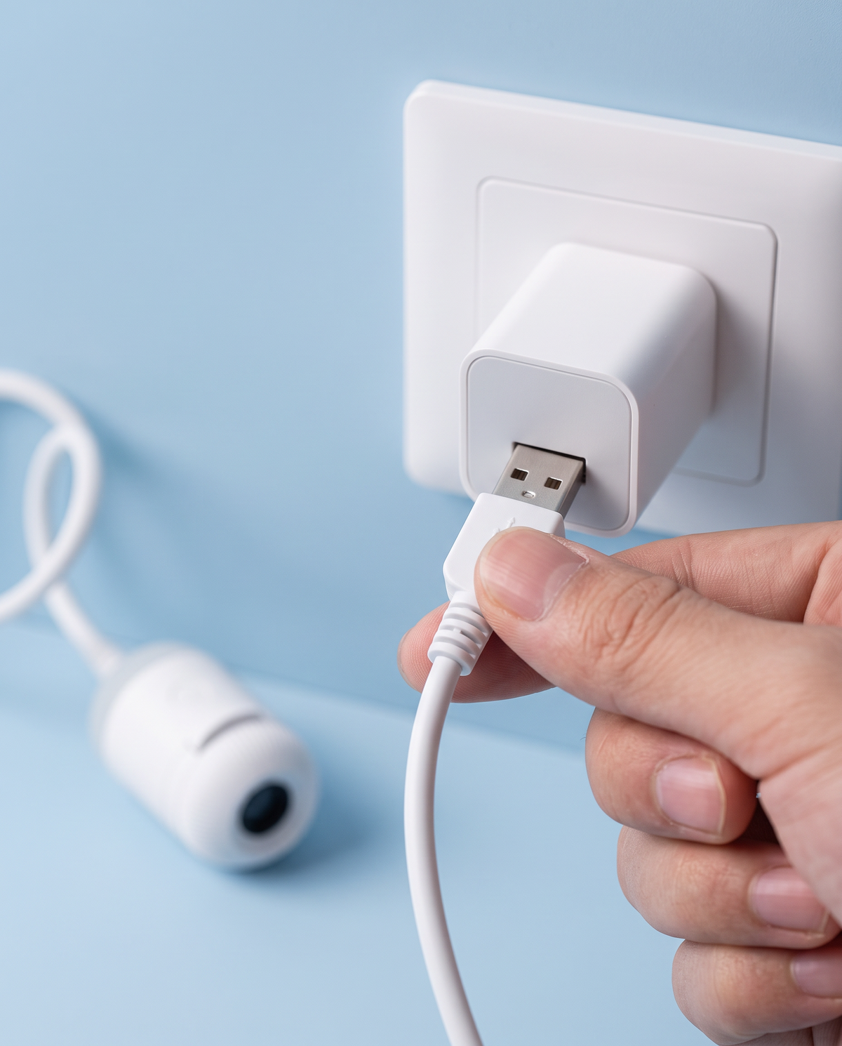 Plugging the projector's USB cable into a charger
