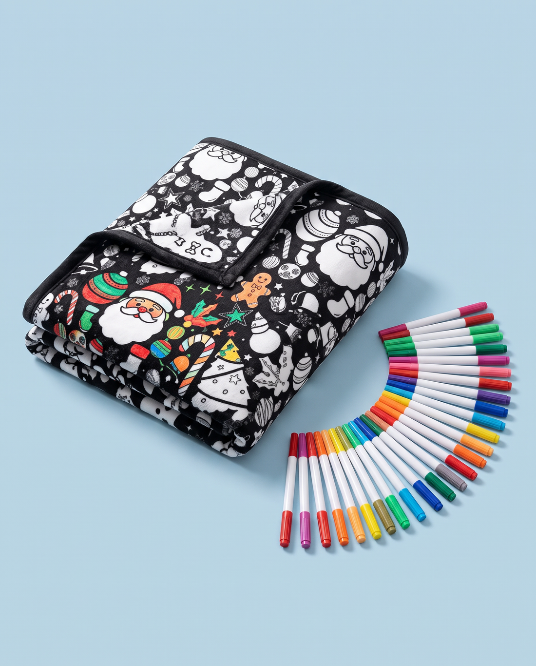 Folded Christmas coloring blanket with 24 markers on a powder-blue background