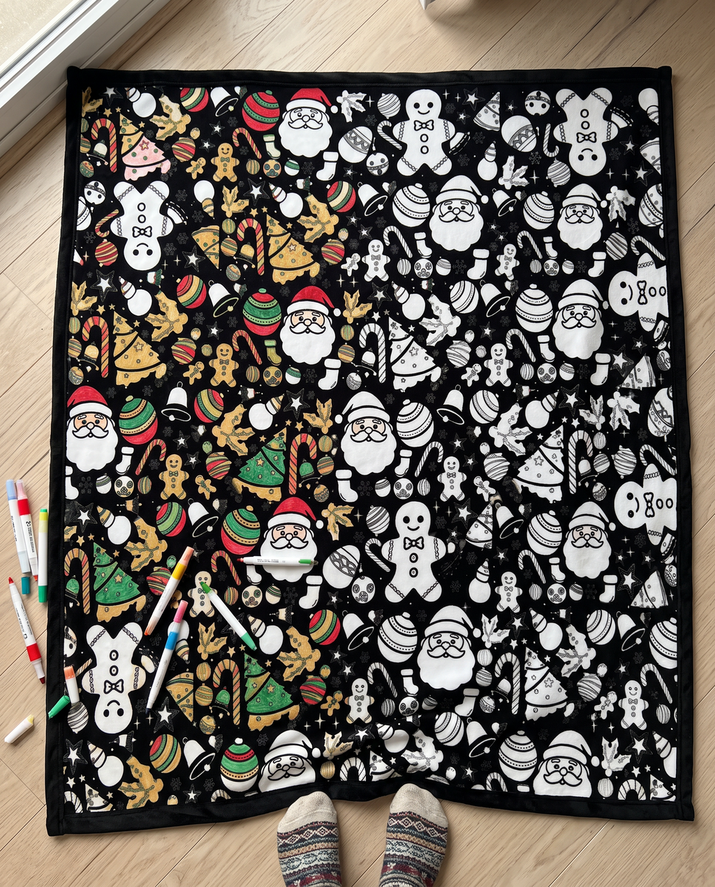 Half colored, half black and white: the Christmas coloring blanket on the floor with markers
