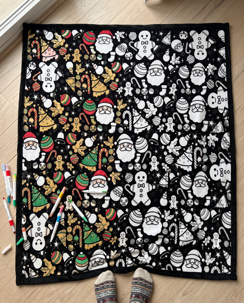 Half colored, half black and white: the Christmas coloring blanket on the floor with markers